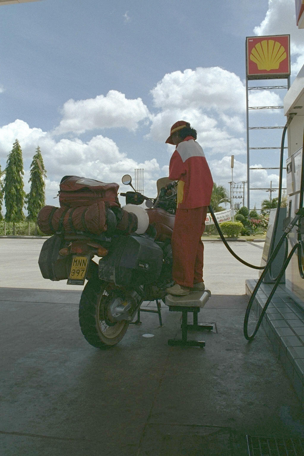 Small(ish) person fills tank of huge bike